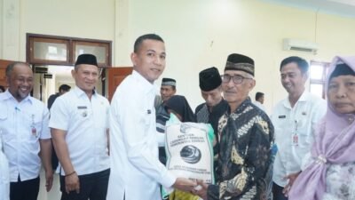 Wakil Bupati Bolmut menyerahkan bantuan beras cadangan pangan kepada warga