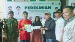Bupati Bolmut Sirajudin Lasena menyerahkan kunci Rumah Layak Huni kepada warga Desa Ollot I
