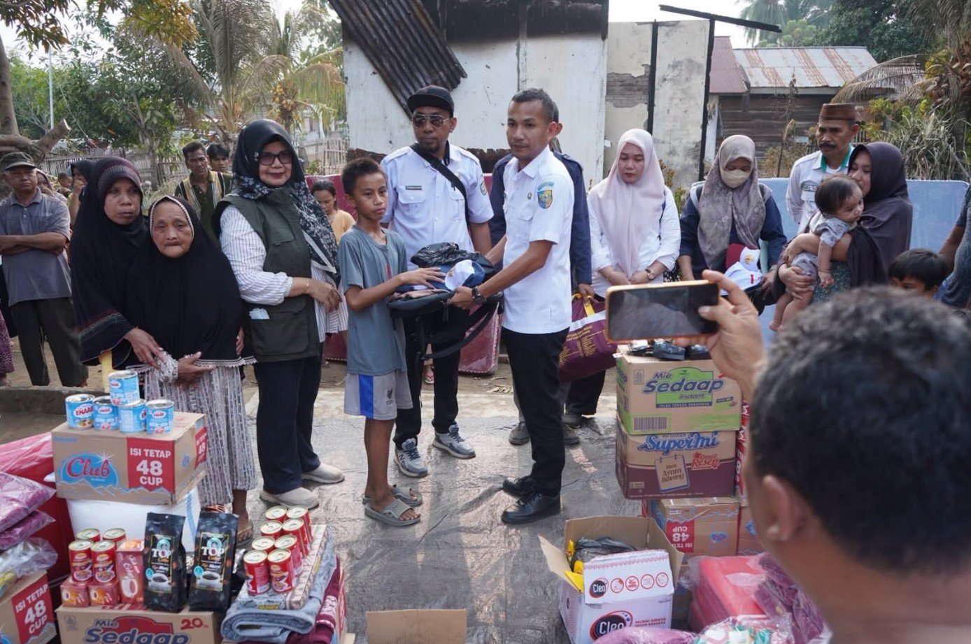 Plt Bupati Bolmut Aditya Pontoh menyerahkan bantuan kepada korban kebakaran rumah di Desa Talaga, Bintauna.